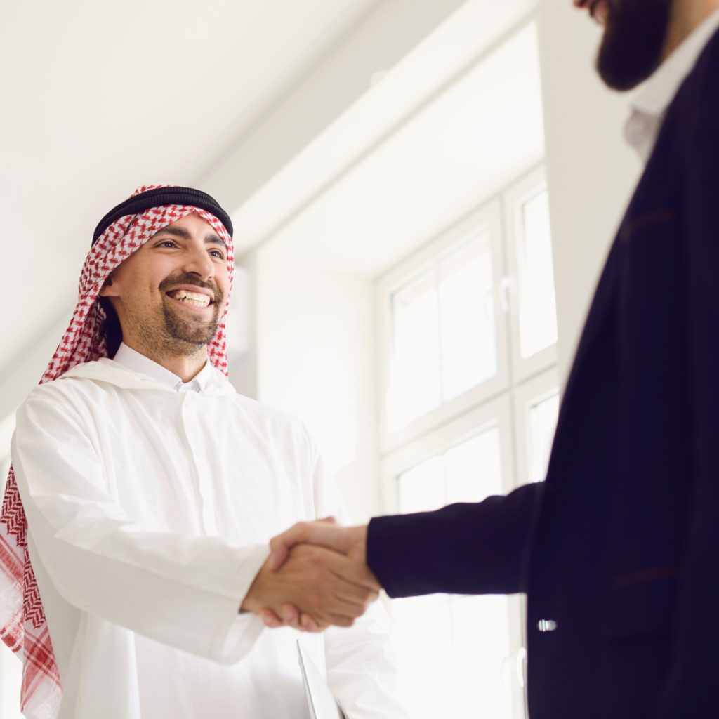 Arab and European businessmen shaking hands