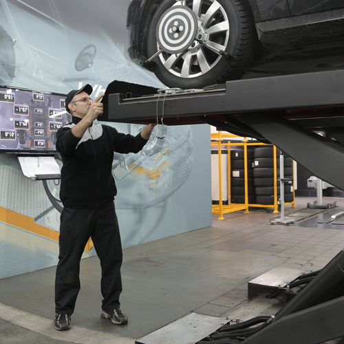 car mechanic inspecting car wheels
