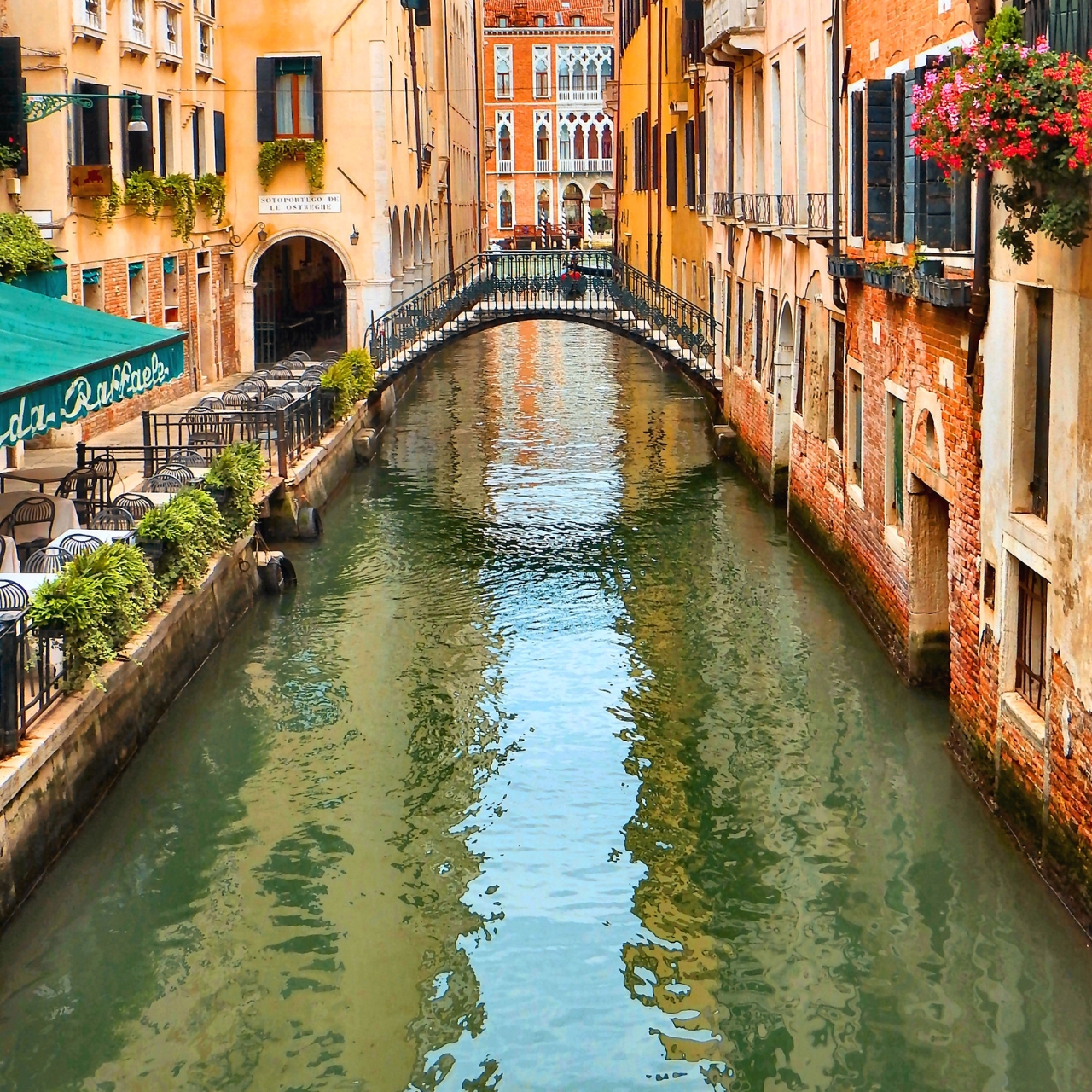 Canal in Venice with typical curved bridge over canal