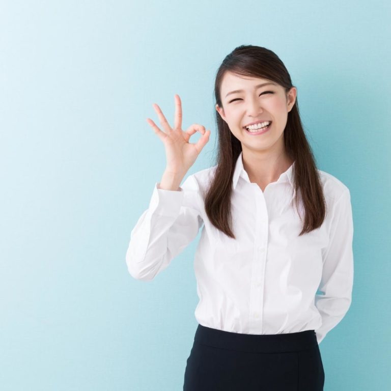 smiling japanese businesswoman showing OK sign with fingers