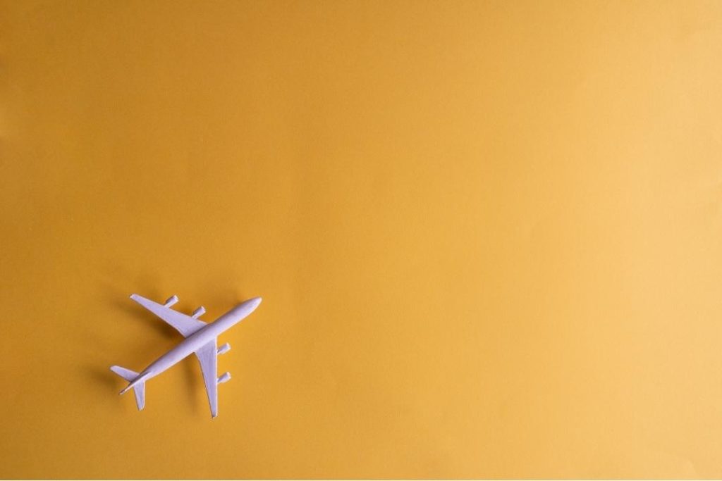 white airplane figurine against yellow background