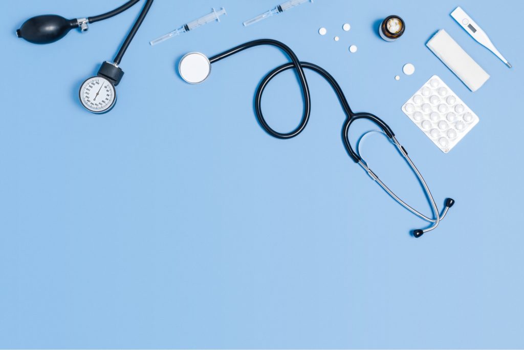 medical blue background with different accessories_ stethoscope, syringe, thermometer, and pills