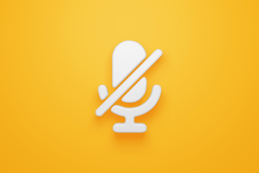 crossed microphone depicting mute sign against yellow background
