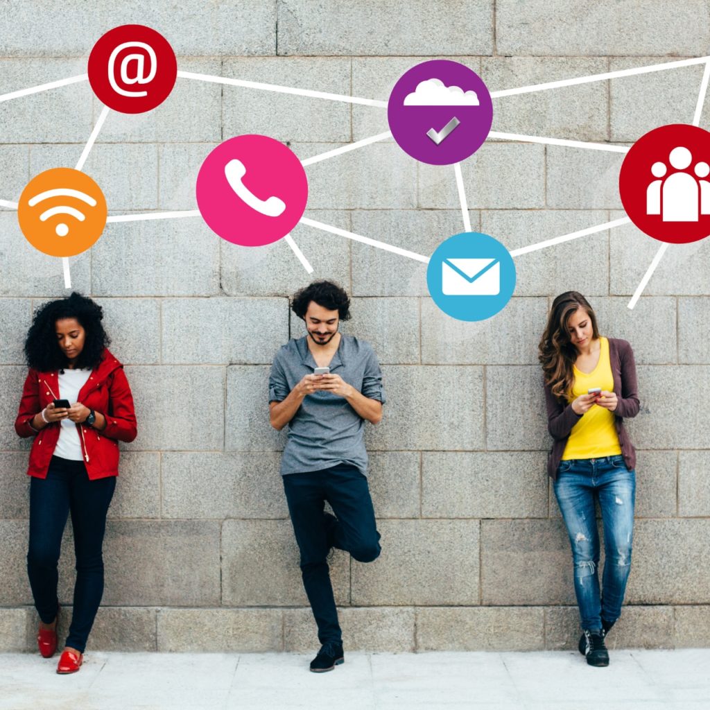 Three people texting on smartphones with social media icons above them connected into a web