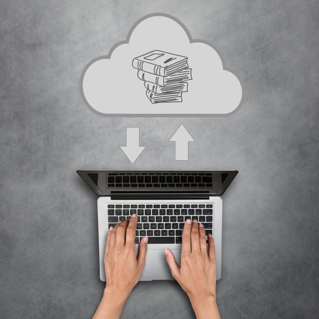 human hands on laptop with illustration of books in cloud. Concept of terminology management tool